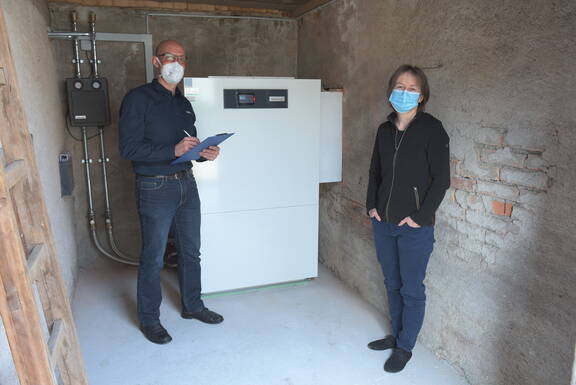 Silvia Müller (rechts) mit Benno Niedermann, Effizienz- und Energieberater IBI, vor der neuen Luft/Wasser-Wärmepumpe.